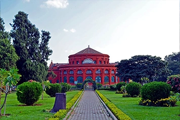 Reach Cubbon Park in Bangalore, a calm green space ideal for morning runs, picnics, and relaxation.